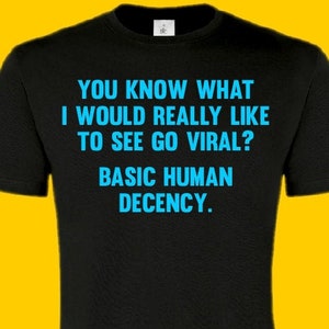 May include: Black t-shirt with the text "YOU KNOW WHAT I WOULD REALLY LIKE TO SEE GO VIRAL? BASIC HUMAN DECENCY." in blue.