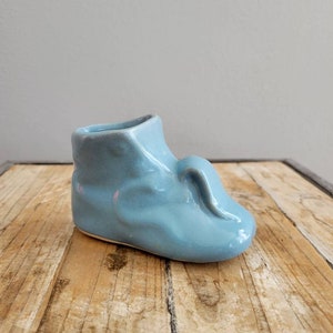 Vintage blå keramikplanter för babysko. Antik inomhusplanter i glas. Suckulentplanter. Blå vas. Gammal retrodekor från mitten av århundradet.