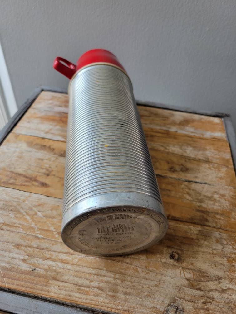 Thermos vintage in alluminio pinta con coperchio rosso. Vecchia tazza  Thermos. -  Italia
