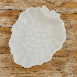 May include: White milk glass dish shaped like a flower with a raised design.