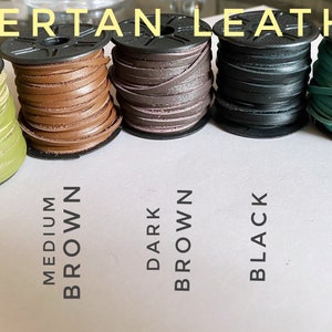 May include: Five spools of leather cord in different colors: olive green, medium brown, dark brown, black, and turquoise. The spools are labeled with the color names.