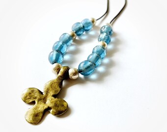 May include: A necklace with a gold-colored cross pendant and blue glass beads.