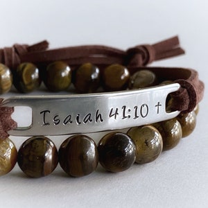 May include: Brown leather bracelet with tiger's eye beads and a silver charm engraved with "Isaiah 41:10 +"
