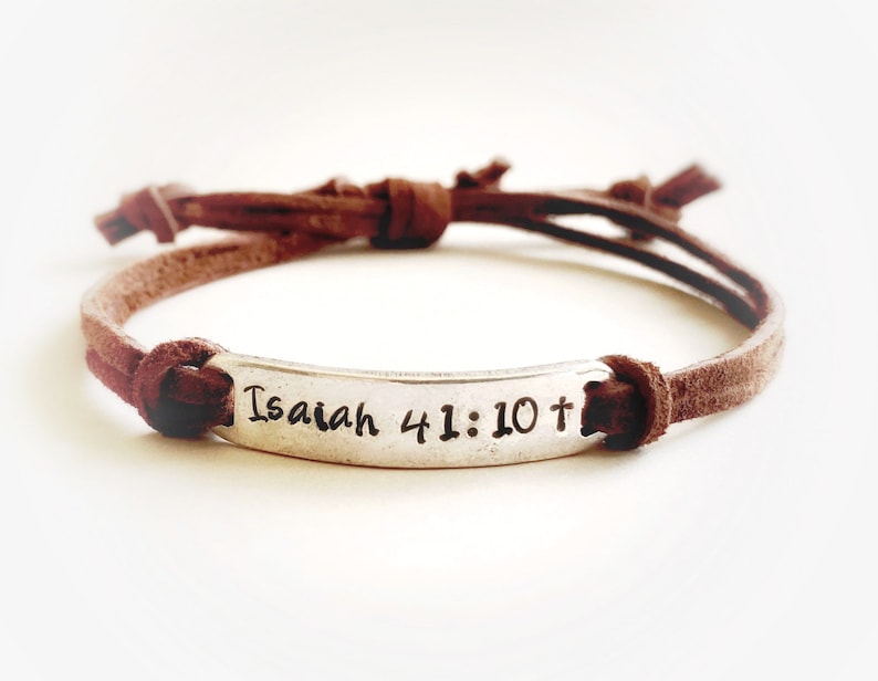 May include: Brown leather bracelet with a silver charm that says "Isaiah 41:10 +"
