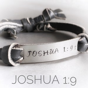 May include: A black leather bracelet with a silver metal plate engraved with the text "Joshua 1:9".