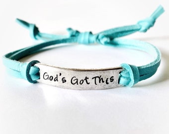 May include: A turquoise leather bracelet with a silver charm that reads "God's Got This".