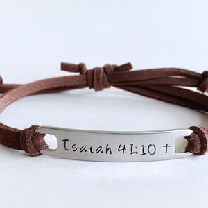May include: Brown leather cord bracelet with a silver metal tag that reads "Isaiah 41:10 +"