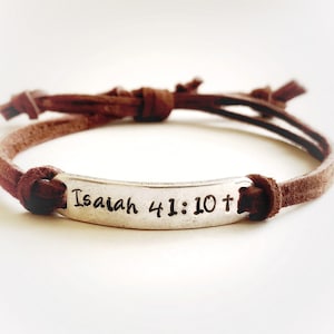 May include: Brown leather bracelet with a silver charm that says "Isaiah 41:10+"