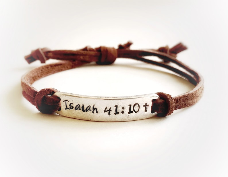 May include: Brown leather bracelet with a silver charm that says "Isaiah 41:10+"