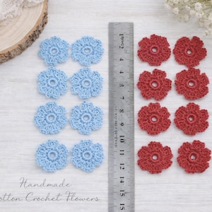 Puede incluir: Flores de ganchillo de algodón hechas a mano en azul claro y rojo. La imagen muestra una regla con medidas en centímetros y el texto "Handmade Cotton Crochet Flowers".