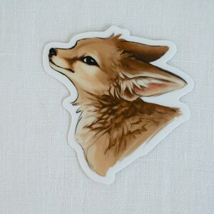 May include: A sticker featuring a close-up of a fox's head. The fox has brown fur and is looking up. The sticker is on a white background.