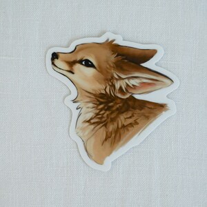 May include: A sticker featuring a detailed illustration of a fox's head, looking up with a curious expression. The fox has brown fur with lighter accents, and its ears are perked up.