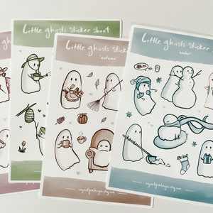 May include: Three sticker sheets featuring cute ghost illustrations. Each sheet has a different theme: autumn, winter, and a general ghost theme. The stickers are printed on white paper with a watercolor background.
