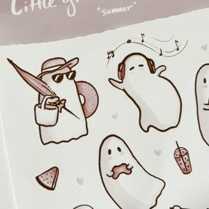 May include: A set of stickers featuring cute ghost illustrations in various summer activities, including listening to music, eating watermelon, and holding an umbrella. The stickers are in a pink and white color scheme with the text "Little ghosts" and "Summer" on the sheet.