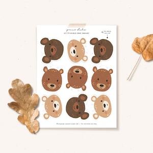 May include: Printable bear head cutouts for a DIY banner. The bear faces are brown, tan, and cream with black eyes and noses. The text on the page reads "DIY Printable Bear Banner".