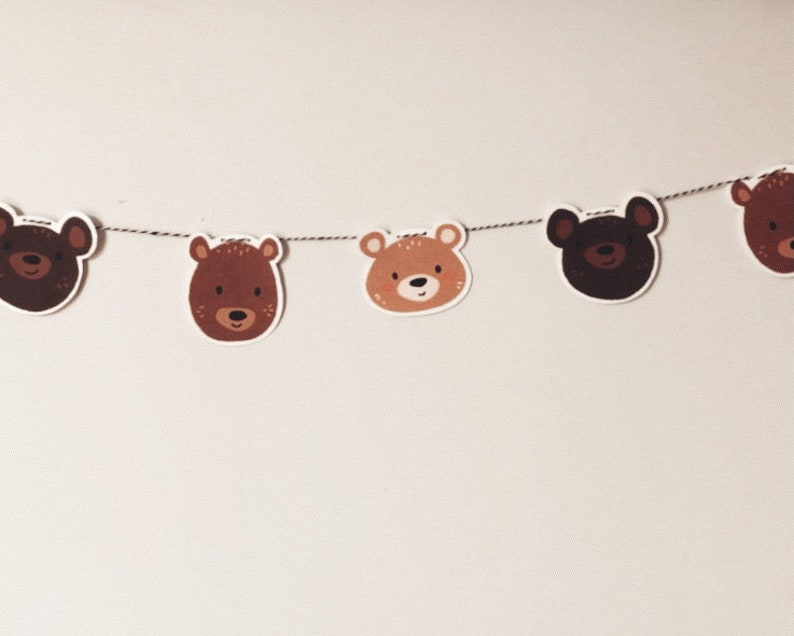 May include: A brown and tan bear head garland with five bear heads strung on a twine string.