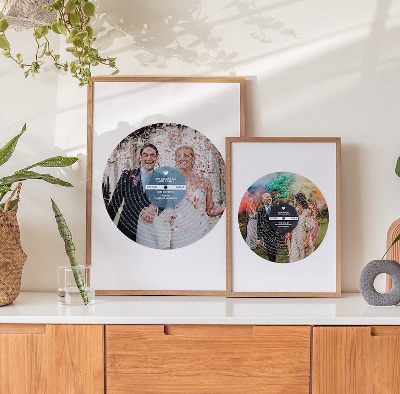 May include: Two framed prints of wedding photos with a record design. The photos are in a circle with the couple in the center. The top print has a blue background and the bottom print has a rainbow background.