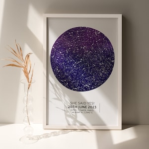 May include: A white framed print with a dark blue and purple star map. The text on the print reads "SHE SAID YES! 20TH JUNE 2023 EIFFEL TOWER, PARIS 48.8584&deg; N, 2.2945&deg; E"