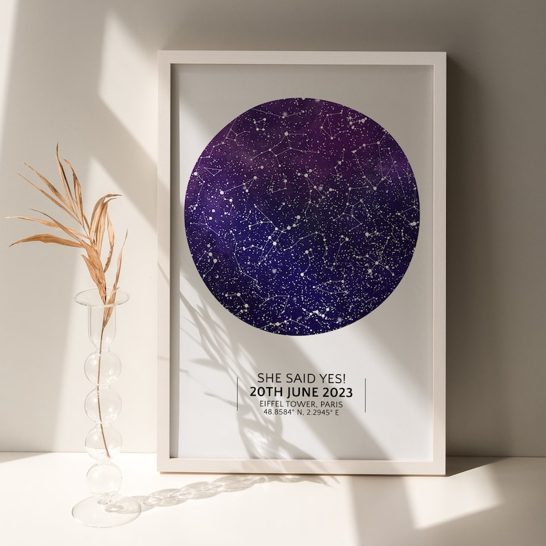 May include: A white framed print with a dark blue and purple star map. The text on the print reads "SHE SAID YES! 20TH JUNE 2023 EIFFEL TOWER, PARIS 48.8584&deg; N, 2.2945&deg; E"