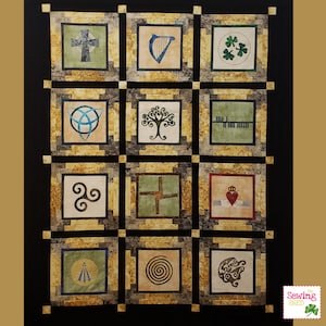 Pode incluir: Um bloco de colcha emoldurado em preto e dourado com 12 símbolos irlandeses diferentes, incluindo uma cruz celta, uma harpa, um trevo e uma árvore da vida. O bloco de colcha é feito de tecido com uma aparência texturizada e envelhecida.