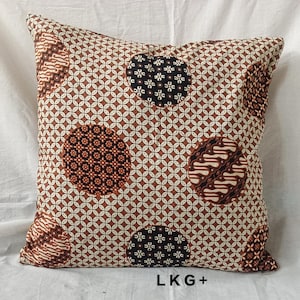 May include: A brown and white patterned pillow with a geometric design and circles of different batik patterns. The pillow has a brown border and the text "LKG+" is printed on the bottom.