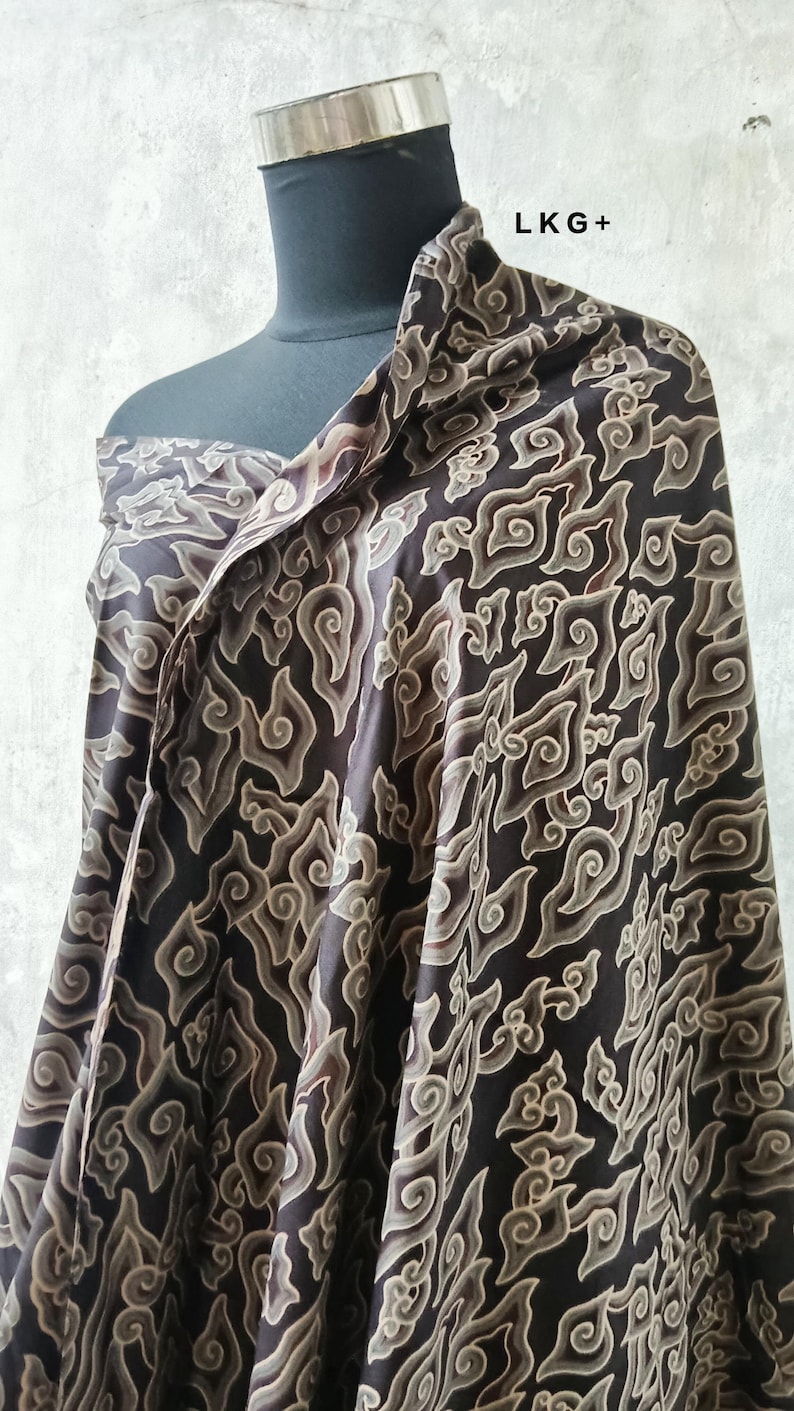 May include: A black and brown patterned fabric with a swirling design. The fabric is draped over a mannequin.