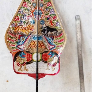 Op de afbeelding: Een kleurrijke, driehoekige, handgeschilderde, papieren waaier met een zwarte stok. De waaier heeft een gouden achtergrond met ingewikkelde ontwerpen en een rode rand. De waaier is versierd met afbeeldingen van dieren, bloemen en geometrische patronen.