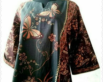 May include: A dark teal tunic with a butterfly and floral design. The tunic features three-quarter sleeves and a mandarin collar with a small V-neck. The butterflies are in shades of orange and brown, with floral accents.