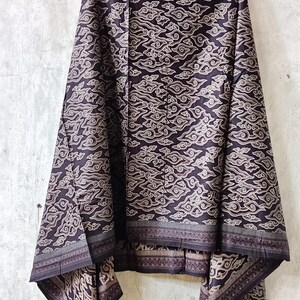 May include: Black and white batik fabric with a cloud pattern. The fabric has a border with a geometric design.