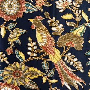 Puede incluir: Tela azul oscuro con un detallado estampado floral y de pájaros. El diseño presenta flores amarillas, marrones y blancas, junto con un pájaro posado en una rama. La tela tiene un estilo artístico tradicional.