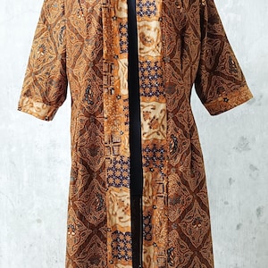 May include: A long brown and gold patterned kimono with a contrasting blue and gold patterned lining. The kimono has a wide collar and three-quarter sleeves.