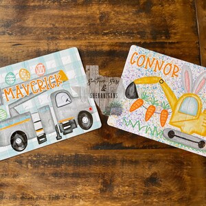 May include: Two personalized Easter puzzles featuring a gray truck with a lift and a yellow excavator. The truck puzzle has the name "Maverick" and the excavator puzzle has the name "Connor". Both puzzles have a blue and white checkered background with Easter eggs and carrots.