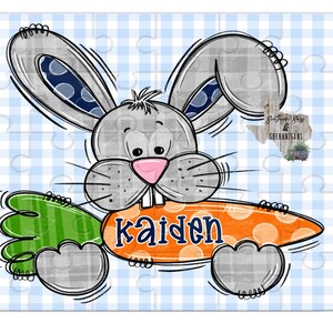 May include: A gray bunny rabbit with blue polka dots on its ears holds a large orange carrot with white polka dots and the name "Kaiden" written in blue letters.