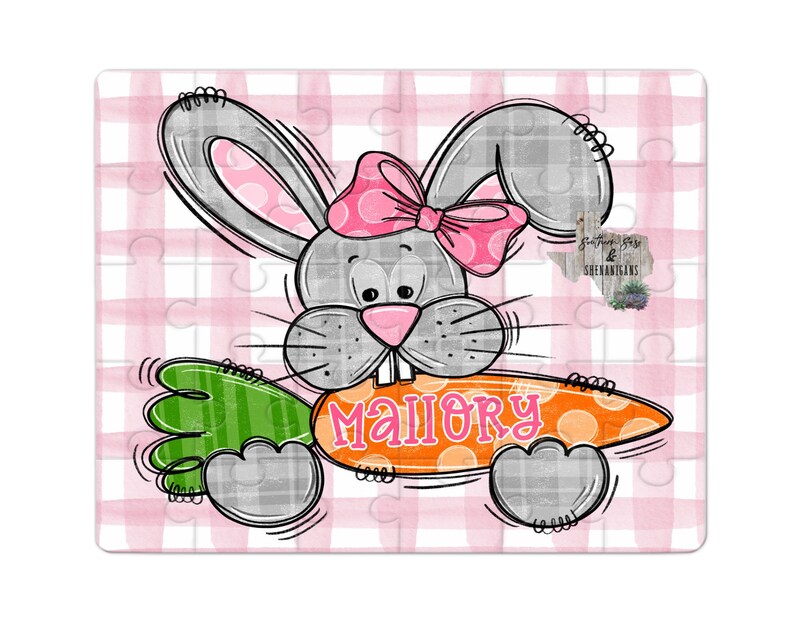 May include: A gray bunny with pink bow holding a carrot with the name Mallory written on it. The bunny is on a pink and white gingham background.
