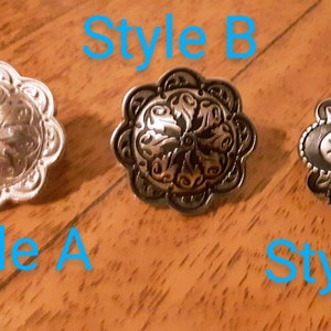 May include: Three decorative metal conchos in different styles. Style A is silver with a floral design. Style B is a dark silver with a floral design. Style C is dark silver with a star in the center. The text "Style A", "Style B", and "Style C" are in the image.