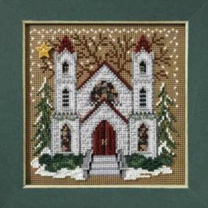 May include: Cross-stitch artwork of a church with two white towers and a red door. The church is decorated with Christmas trees and a gold star. The background is a light brown color.