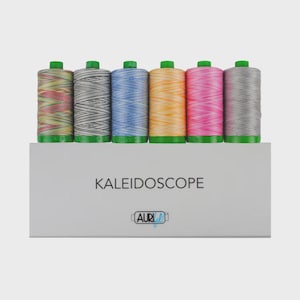 May include: Six spools of thread in a row, each with a green base, featuring variegated colors including red, yellow, grey, blue, orange, and pink. The spools sit atop a white box labeled KALEIDOSCOPE with the AuriFil logo printed in black.