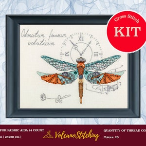 May include: Cross stitch kit featuring a steampunk dragonfly design. The framed artwork includes a dragonfly with gears, clock elements, and the text "Odonatum fernum volaticum." The design is 11x8 inches (28x20 cm) and uses 20 thread colors.