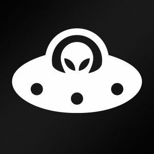 Op de afbeelding: Witte afbeelding van een UFO met een aliengezicht op een zwarte achtergrond. De UFO heeft een klassieke schotelvorm met drie cirkelvormige lichten aan de onderkant. De alien heeft grote ogen en een kleine mond.