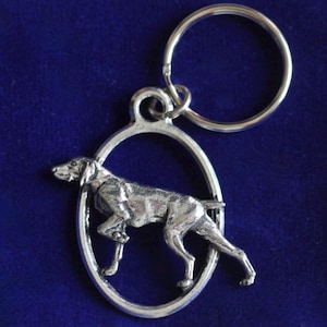 May include: Silver key chain with a detailed German Shorthaired Pointer dog charm. The dog is in a running pose inside an oval frame.