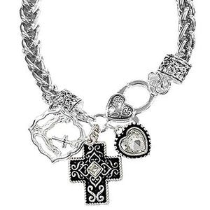 May include: Silver-toned bracelet with a braided chain design. The bracelet features decorative charms, including a cross, a heart, and a heart-shaped charm with a clear stone. The charms are detailed with intricate patterns.