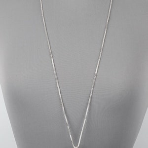 Puede incluir: Un collar de cadena de plata con un colgante en forma de l&aacute;grima. El colgante est&aacute; decorado con un dise&ntilde;o texturizado.