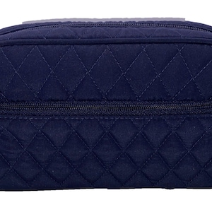 May include: A black quilted makeup bag with a zipper closure and the Vera Bradley logo.