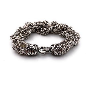 May include: A silver bracelet with a twisted chain design and ornate end caps.