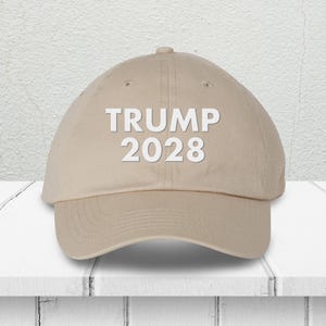 Pode incluir: Um bon&eacute; de beisebol bege com o texto "TRUMP 2028" bordado em branco na frente.
