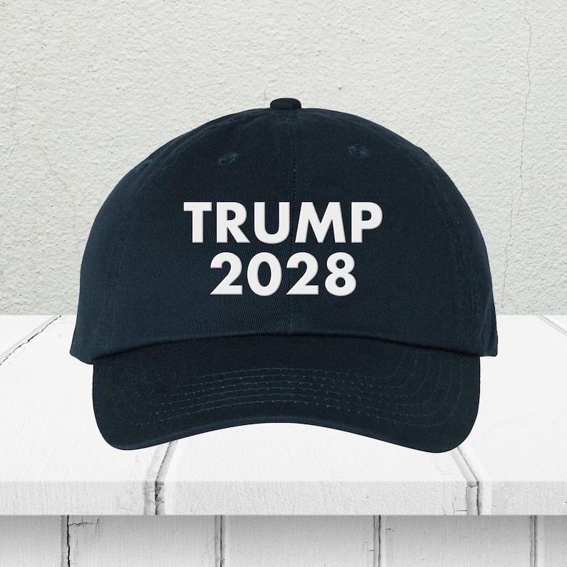 Pode incluir: Um bon&eacute; de beisebol azul escuro com texto bordado em branco que diz "TRUMP 2028".