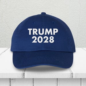 Pode incluir: Um bon&eacute; de beisebol azul com texto bordado em branco que diz "TRUMP 2028".