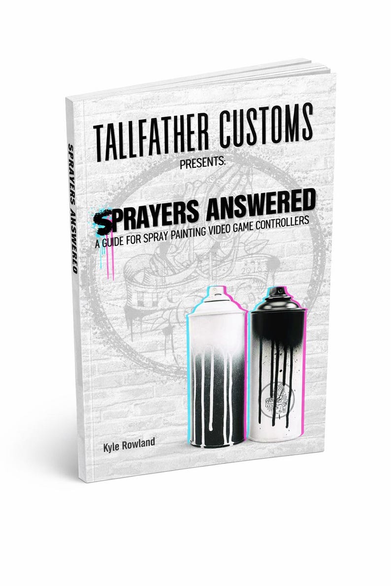 May include: A softcover book titled Tallfather Customs Presents: Sprayers Answered, A Guide for Spray Painting Video Game Controllers by Kyle Rowland. The cover features a white brick background with two spray paint cans showing paint drips.