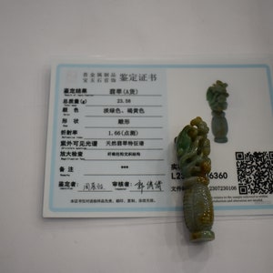Puede incluir: Un colgante de jade tallado en forma de dragón con un esquema de color verde y amarillo. El colgante pesa 23,58 gramos y tiene un índice de refracción de 1,66. El colgante viene con un certificado de autenticidad.