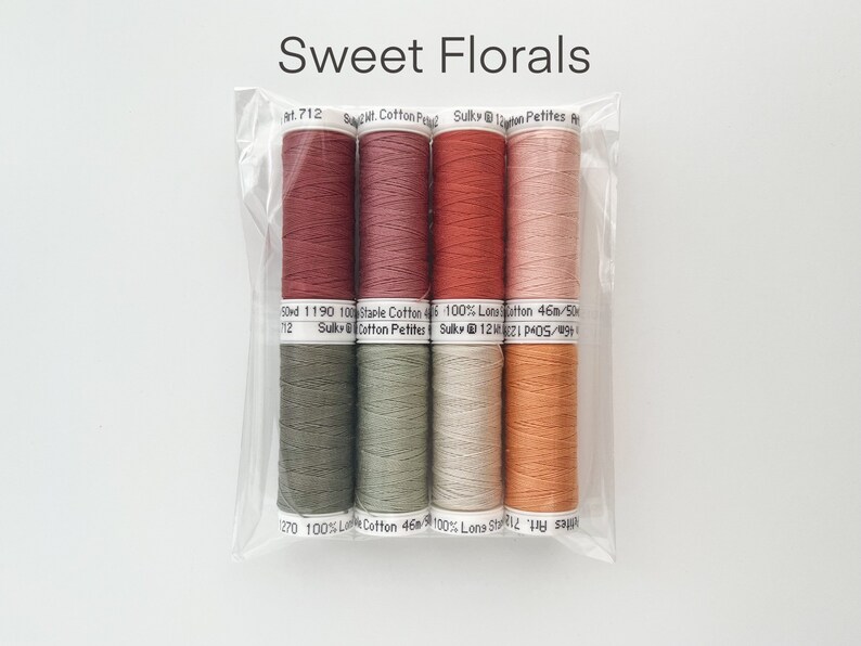 May include: Six spools of thread in various shades of red, orange, green, and beige. The thread is labeled "Sulky Cotton Petites" and "100% Long Staple Cotton".